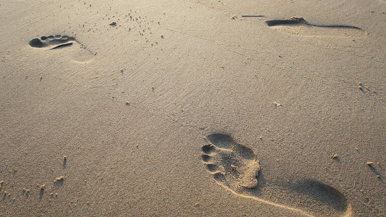 zwei Fußspuren im Sand