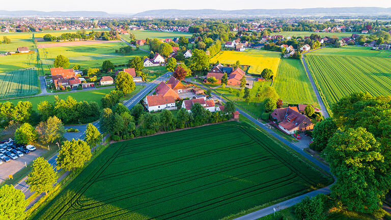 Luftaufnahme von kleinem Dorf mit umliegenden Feldern