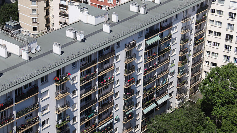Blick auf Wohnblock mit baumbestandener Grünfläche aus der Vogelperspektive
