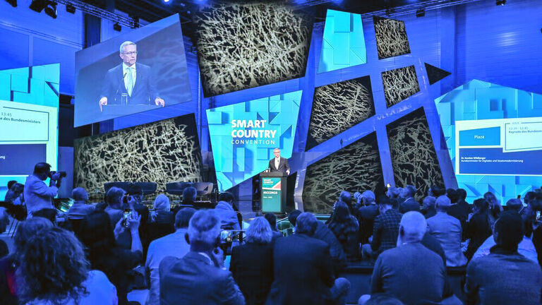 Blick über die Zuschauerreihen auf die Hauptbühne der SCCON 2025, wo Bundesdigitalminister Dr. Karsten Wildberger am Redepult steht
