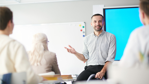 Know-how vom Experten: die IT-Fortbildung der HZD Schulungssituation mit Dozent, der vor einer Anzeigentafel sitzt