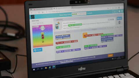 Man sieht einen Laptop-Bildschirm mit der Programmieroberfläche des Programms Dance Party der Non-Profit-Organisation Code.org