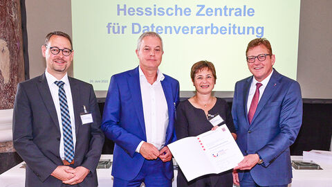 Staatssekretär Stefan Sauer gratuliert der HZD, die durch Dr. Anette Knedla (Gleichstellungsbeauftragte), Joachim Kaiser (Direktor) und Hans-Georg Ehrhardt-Gerst (Leiter des HZD-Standorts Hünfeld) vertreten wurde.  Übergabe der Verleihungsurkunde des Gütesiegels „Familienfreundlicher Arbeitgeber“ durch Staatssekretär Stefan Sauer an die HZD, die durch drei Personen vertreten wird