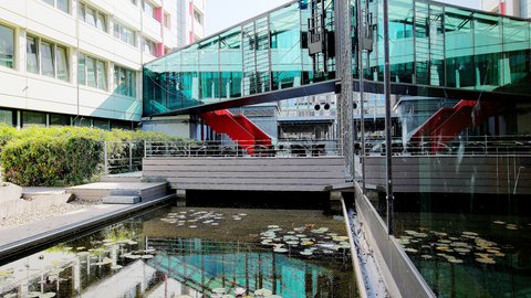 Impression des Innenhofs am Standort Wiesbaden mit Spiegelung der Gebäude in einem Wasserbecken