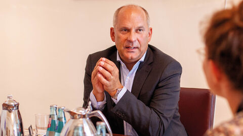Im Gespräch mit der HZD-INFORM: Prof. Dr. Roman Poseck, Hessischer Minister der Justiz Prof. Dr. Roman Poseck am Schreibtisch im Gespräch mit der INFORM-Chefredakteurin