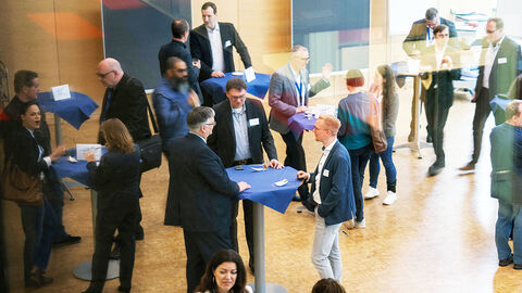 Reger Austausch in Sachen Cloud: das CTf-Kundenforum der HZD Blick in den großen Konferenzraum der HZD, bei dem die Teilnehmenden des Kundenforums Cloud-Transformation sich an Stehtischen in lockerer Gruppierung austauschen