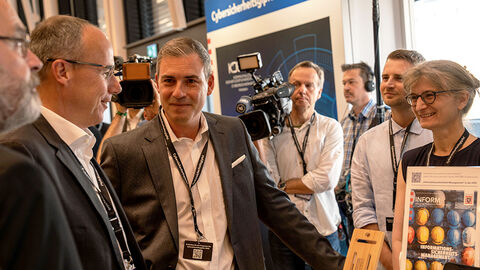 Gemeinsam für mehr Cybersicherheit: Innenminister Peter Beuth (2. v.l.) und Thomas Kaspar, Technischer Direktor der HZD (3. v. l), mit seinem Team Innenminister Peter Beuth gemeinsam mit Thomas Kaspar, dem Technischen Direktor der HZD, und weiteren Personen am Stand der HZD beim Cybersicherheitsgipfel 2023