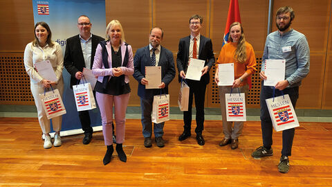 Gruppenfoto der Preisträger des KI-Ideenwettbewerbs mit Digitalministerin Prof. Dr. Kristina Sinemus im Vordergrund und HZD-Mitarbeiter Detlef Winkelvoß in der Bildmitte