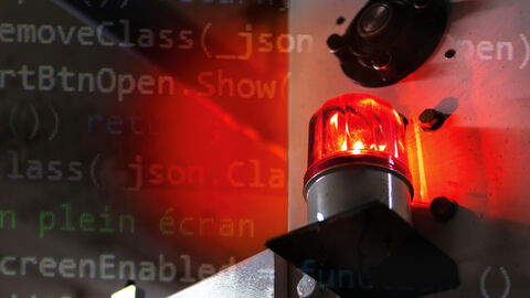 Großaufnahme von Warnleuchte vor unscharf gehaltenen Wand in einer Industriehalle, darüber gelegt eine Grafik aus Programmierbefehlen