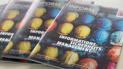 Stapel von mehreren Ausgaben des HZD-Kundenmagazins INFORM mit dem Titel Informationssicherheitsmanagement