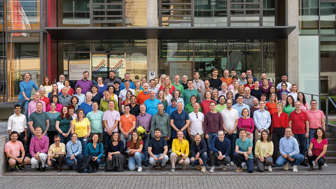 Vielfalt leben am Diversity-Tag 2023 in der HZD Gruppenfoto von ca. 50-80 Leuten in bunter Kleidung vor dem HZD-Gebäude.