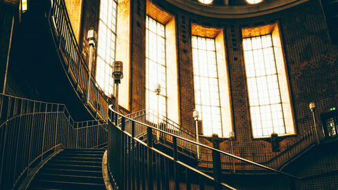 Prachtvolles Foyer mit großen Sprossenfenstern und gewundener Treppe, das an ein Verwaltungsgebäude aus der Gründerzeit erinnert 