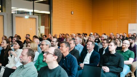 Voll konzentriert und sichtbar motiviert: die Teilnehmerinnen und Teilnehmer der HZD-Fachtagung 2024 Blick in den großen Konferenzraum der HZD, in dem die Teilnehmenden der KI-Fachtagung gebannt einem Vortrag folgen