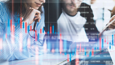 Zwei Personen sitzen vor einem Notebook und schauen auf den Bildschirm. Das Bild ist überlagert von Diagrammen und undefinierten Textzeilen.
