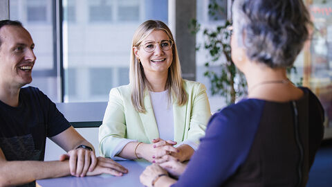 Mitarbeitende der HZD, die sich an einem Stehtisch in lockerer Runde unterhalten