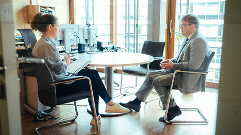 Interviewsituation: Dr. Schweinitz sitzt gegenüber von Redakteurin in einem Büro