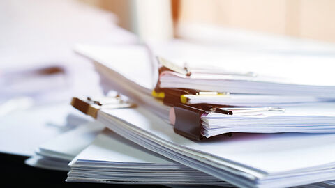 Close-up auf einen Stapel mit von großen Clips zusammengehaltenen Papieren