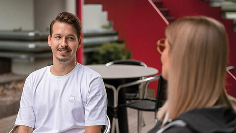 Beste Voraussetzungen für eine aussichtsreiche Karriere – die Fachinformatikausbildung bei der HZD Junger Mann beim Gespräch mit Personalexpertin im Innenhof der HZD