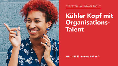 Porträt einer sympathisch aussehenden IT-Expertin mit roten Haaren und auffällig bunten Fingernägeln