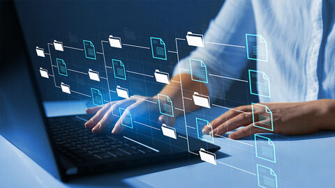 Angeschnittener Oberkörper einer Person am Tisch vor einem Laptop. Eine Hand liegt auf dem Tisch an, die andere liegt auf der Tastatur des Laptops. Das Bild ist überlagert von digitalen Ordnersymbolen, die netzartig miteinander verbunden sind.