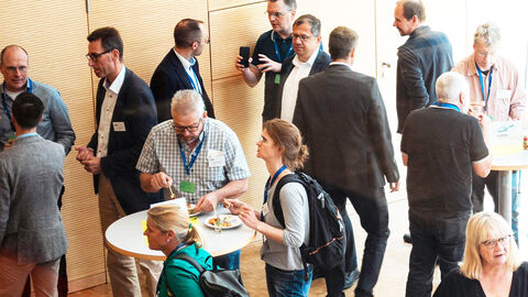 Blick von oben in den großen Konferenzraum der HZD, bei dem sich Gäste des Cloud Kundenforums in der Kaffeepause austauschen