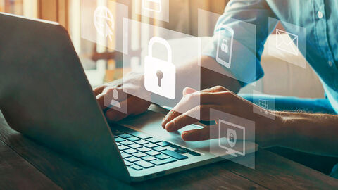 Close-up auf die Hände eines Mannes auf Laptoptastatur, darüber gelegt halbtransparente Grafikelemente, die das Thema Cybersecurity symbolisieren