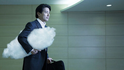Close-up auf businessmäßig gekleideten Mann in einem U-Bahn-Tunnel, der in der Hand einen Aktenkoffer trägt und eine weiße Wolke unter den Arm geklemmt hat